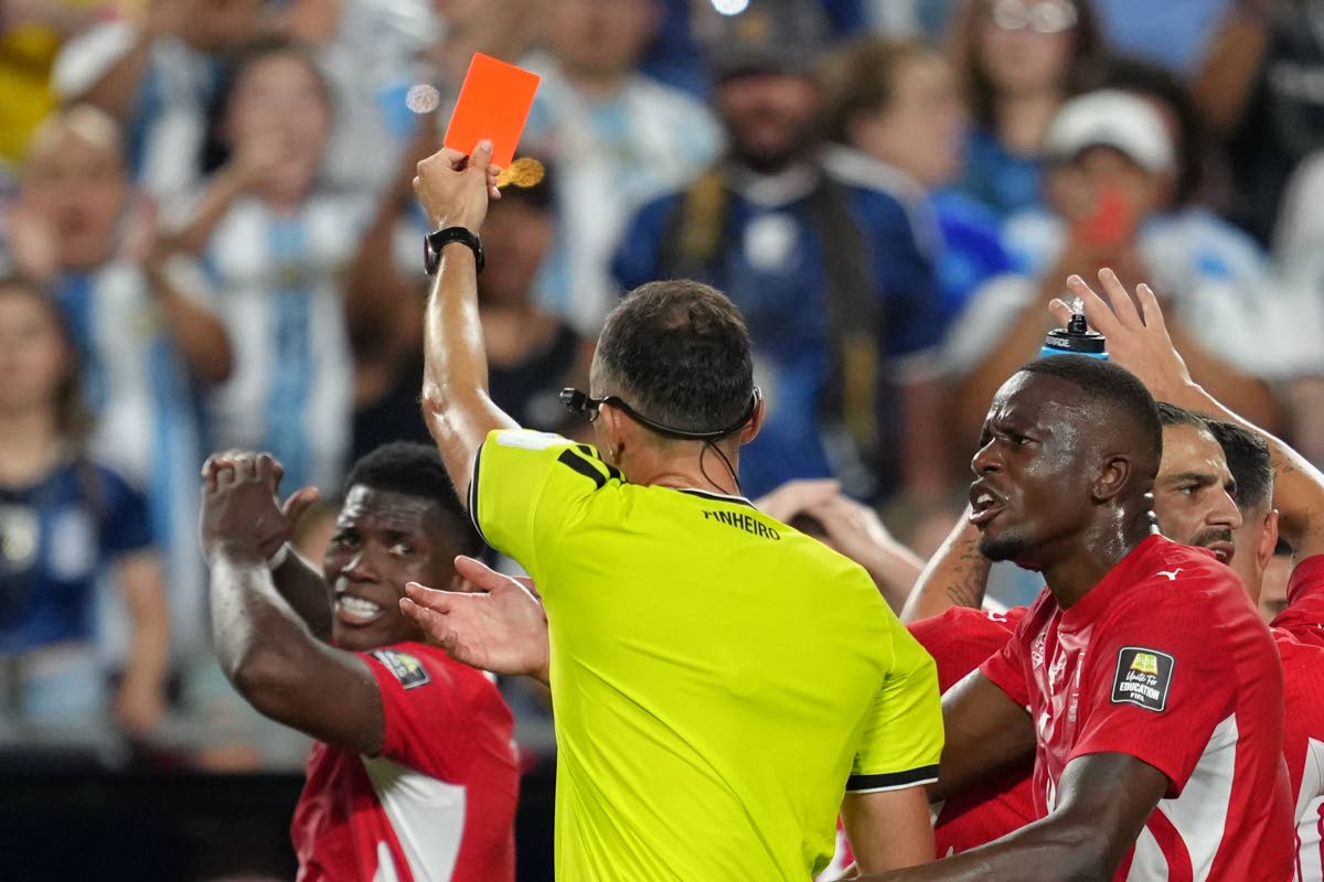 Referee Joao Pinheiro (centre), of Portugal, gives a red card to Switzerland's Breel Embolo (left) during the World Cup quarterfinal football match against Argentina in Kansas City, Missouri, Saturday, July 11.