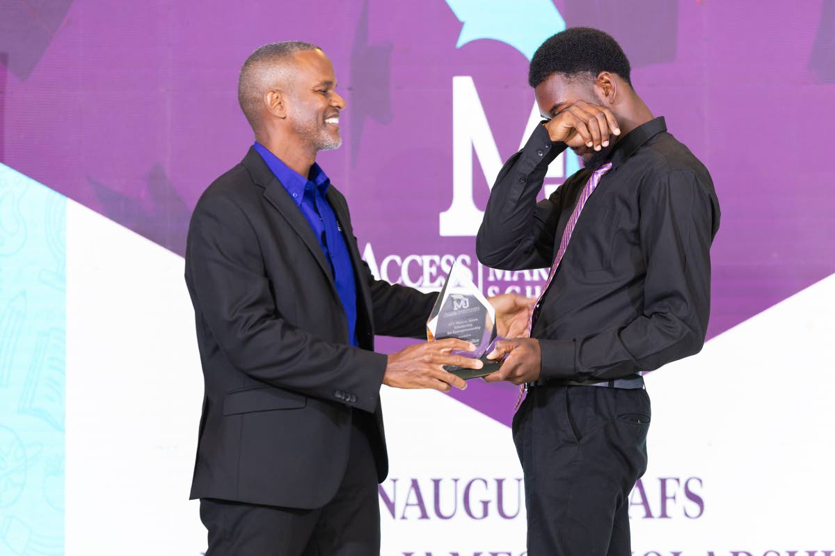 Access Financial Services Founder and Executive Director Marcus James (left) presents the inaugural AFS Marcus James Scholarship for Entrepreneurship award to a very emotional Alfred Fuller.