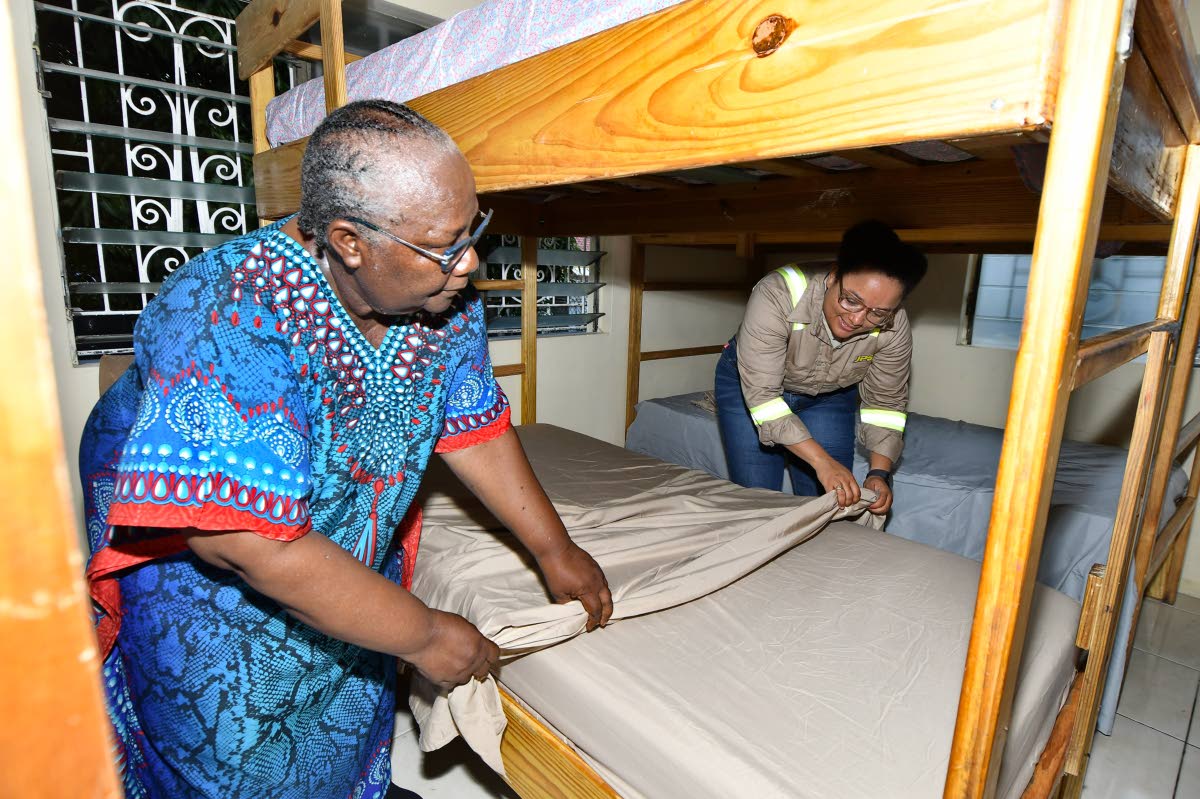 Annie Dawson Children’s Home founder Ivaline Nickie gets assistance in making the bed in one of the girls’ dormitories from Timara Jackson, who has been an avid supporter of the home for the last two years. 