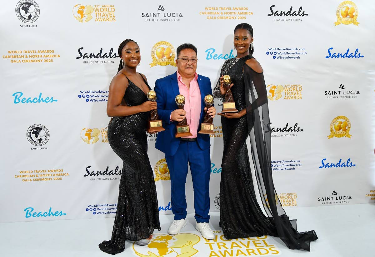 Go! Jamaica Travel’s Dave Chin-Tung (centre) is flanked by two World Travel Awards models as he collected four prizes at the event at Sandals St Lucia last Saturday night.