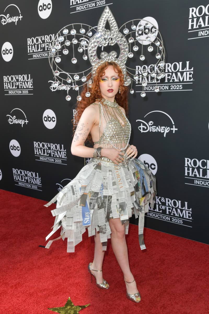 Chappell Roan pays tribute to Cyndi Lauper in a custom ‘True Colors’-inspired fit. Roan dons a headpiece by Manny Robertson, a custom newspaper skirt by Efrain Nava, and metallic gold Christian Louboutins.