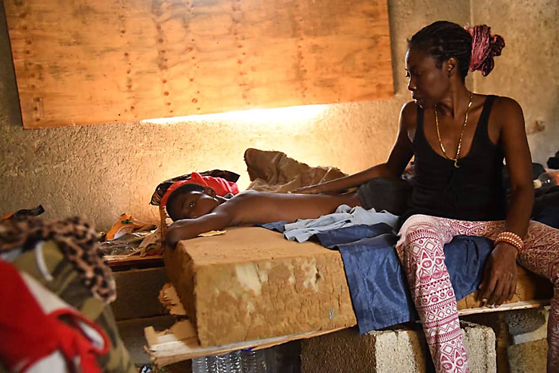 Joel Wynter who is suffering from sickle cell disease being tended by his mother.