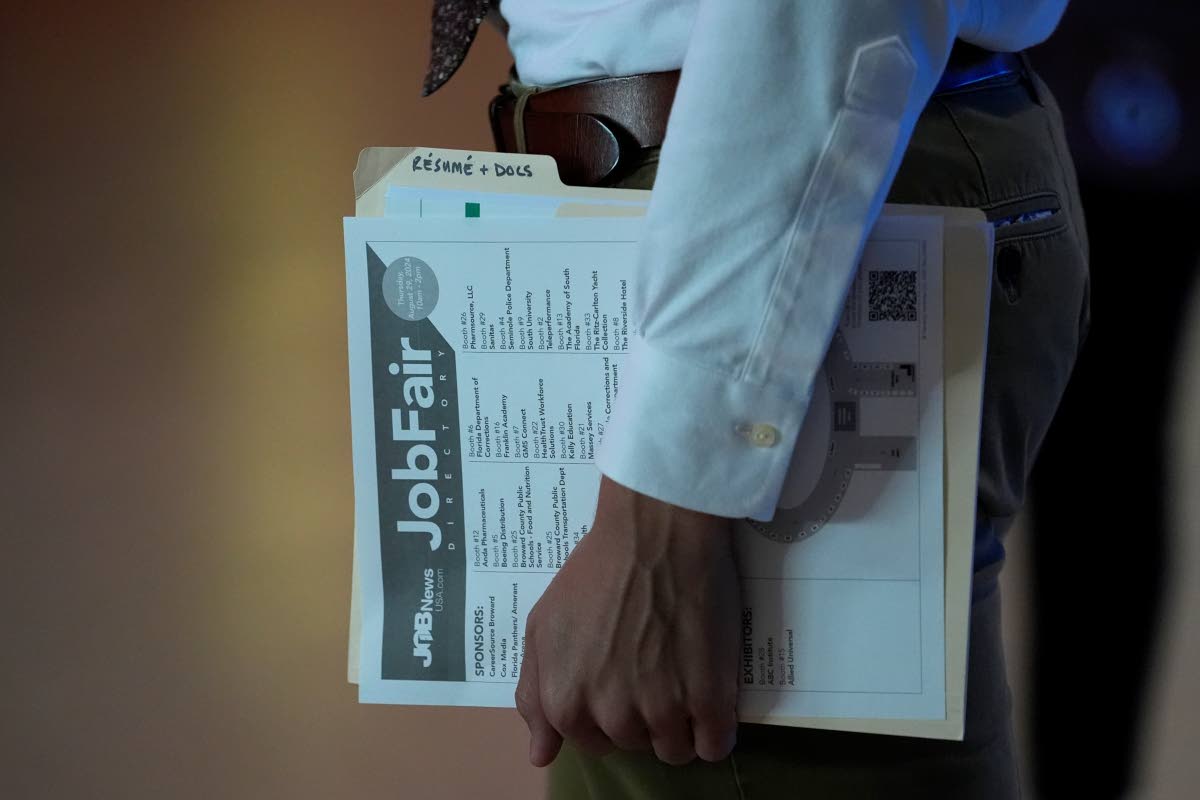 A person waits in a line for a prospective employer at a job fair, in Florida.