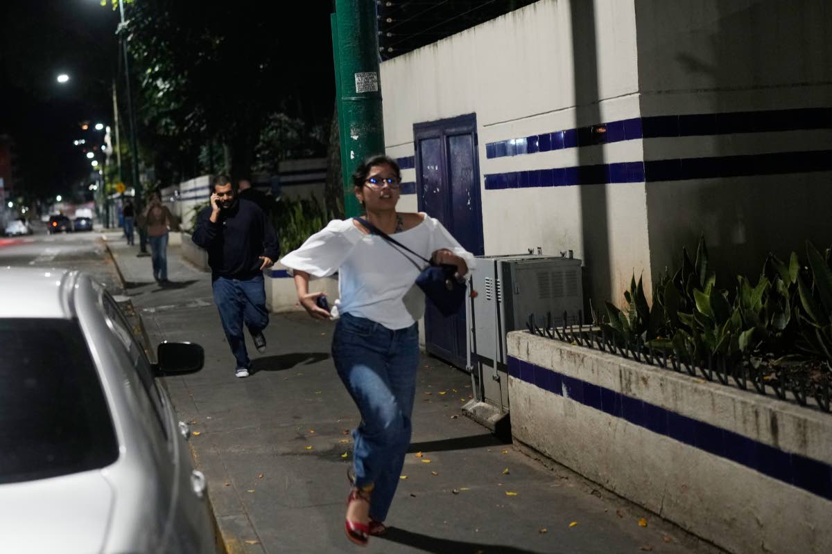 Pedestrians run after explosions and low-flying aircraft were heard in Caracas, Venezuela, on Saturday.
