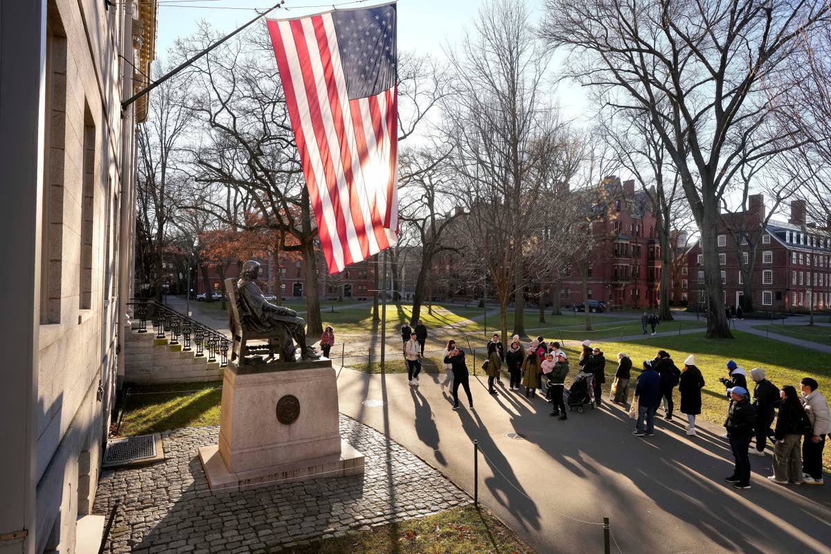 
In this January 2024 photo people are seen taking photos near a John Harvard statue, left, on the Harvard University campus, in Cambridge, Massachusetts.