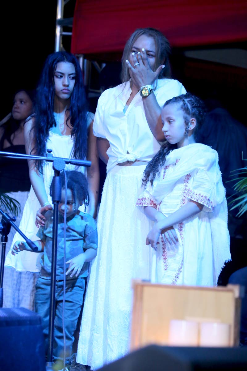 An emotional Kerry-Ann Smith (centre) wipes away tears for her son, Joseph ‘Jo Mersa’ Marley, while standing with his daughter, Sunshine Marley (right), and surrounded by family.
