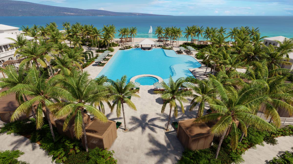 An aerial image of the main pool at Sandals South Coast, where lush palms and meandering walkways frame a serene poolside retreat.