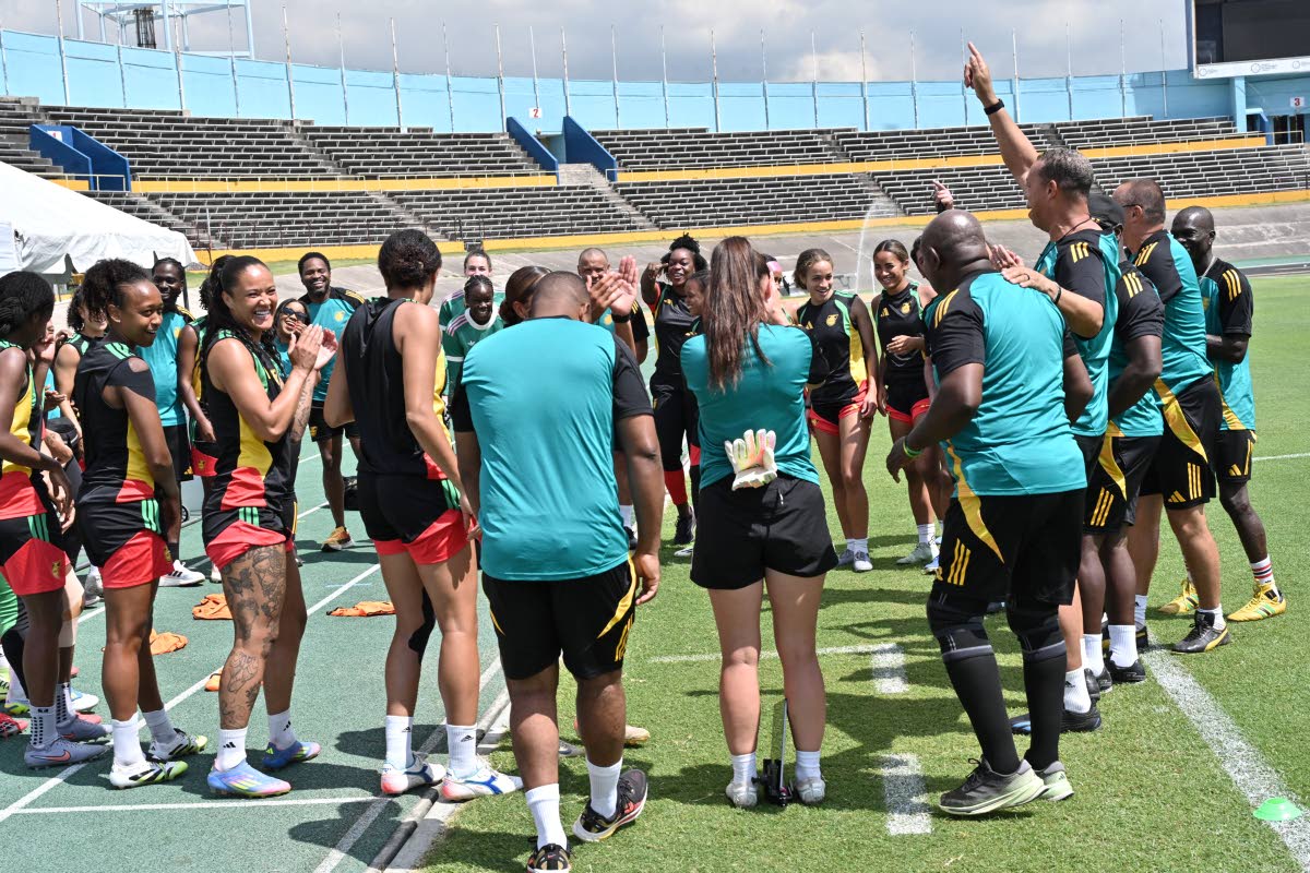 Reggae Girlz coach Hubert Busby Jr (arm raised) rallies his troops during a training session at the National Stadium on April 17.
