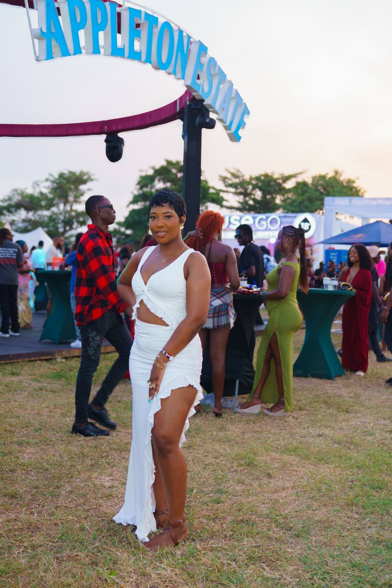 Mikhalia Campbell strikes a pose in a ruffle-trimmed cut-out maxi, featuring a thigh-high slit.