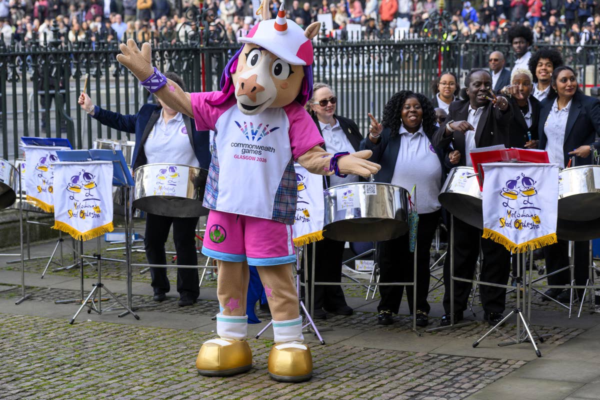 Finnie, the official mascot for the Glasgow 2026 Commonwealth Games, poses for a photo with the members of Melodians Steel Orchestra at the Commonwealth Day Service of Celebration at Westminster Abbey in London on March 9. 