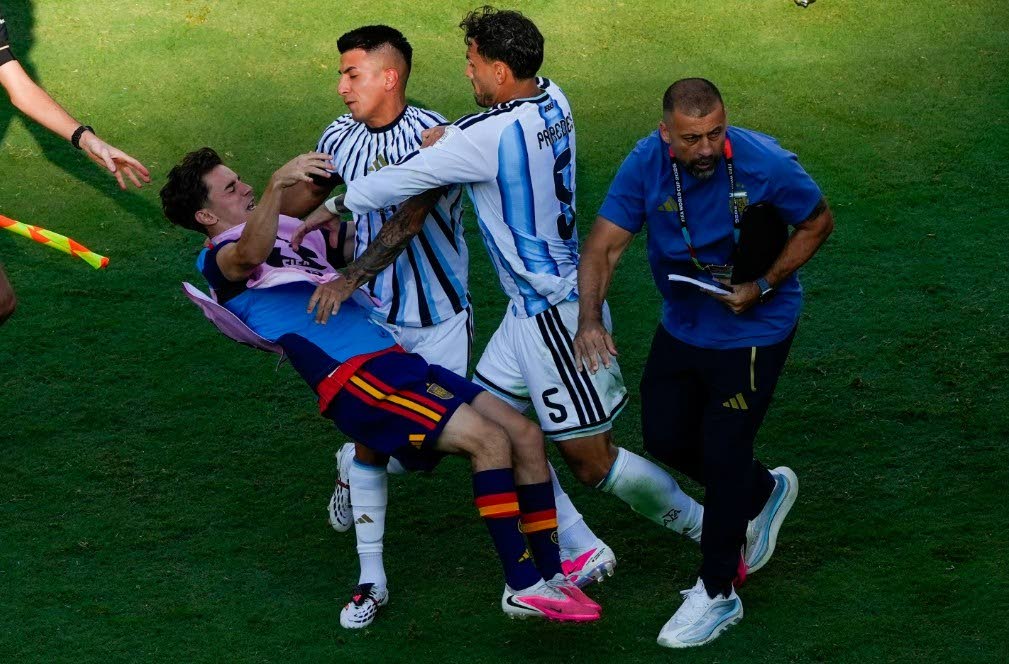 Spain's Gavi, left, falls as he scuffles with Argentina's Leandro Paredes (5) and Thiago Almada during the World Cup final football match between Spain and Argentina in East Rutherford, N.J., near New York, Sunday, July 19, 2026. (AP Photo/Yuki Iwamura)