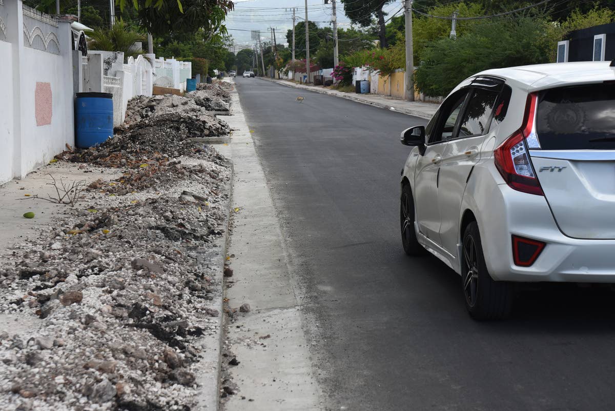 A section of Antrim road in Vineyard Town, St, Andrew that was resurfaced but debris from roadwork has been left on the sidewalk.