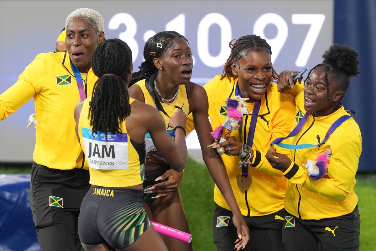 
An absolutely shattered Dejanea Oakley of Jamaica (third left) is mobbed by her teammates after crossing the finish line to win the mixed 4X400-metre relay at the Commonwealth Games in Glasgow, Scotland, yesterday.