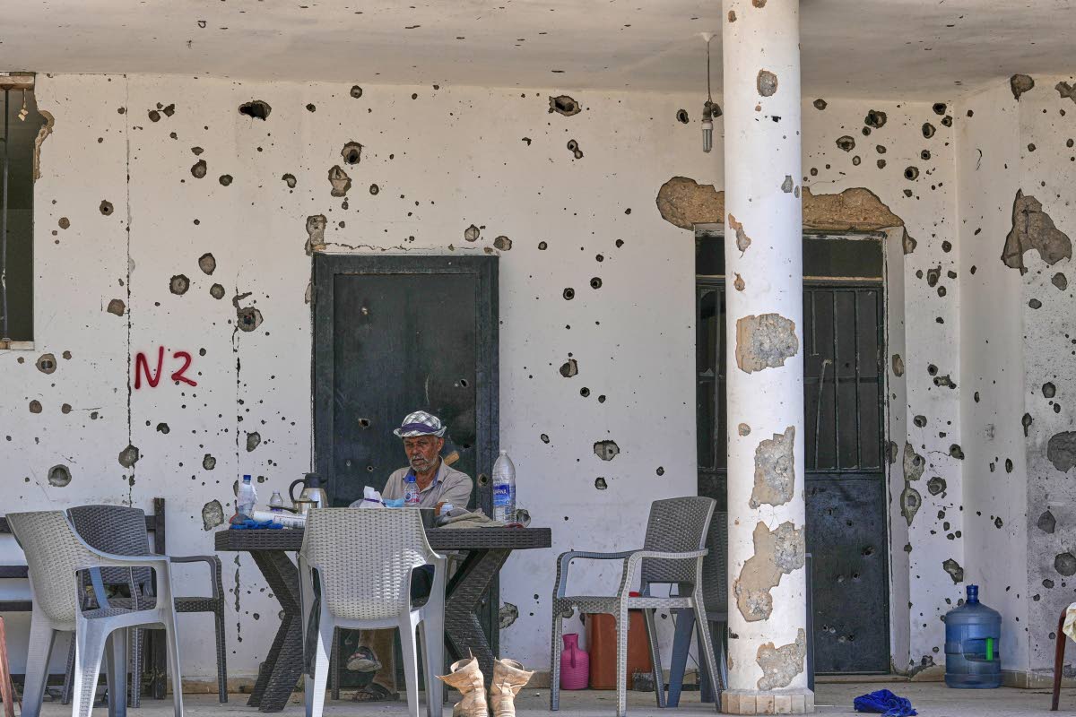 A man sits outside his damaged house in the village of Zawtar al-Gharbieh, south Lebanon.
