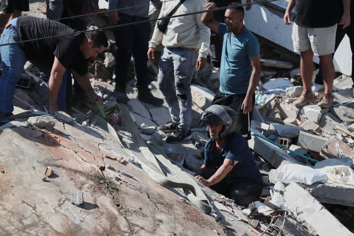 Residents and rescue workers search through the rubble of a collapsed building after an earthquake struck Cali, Colombia.