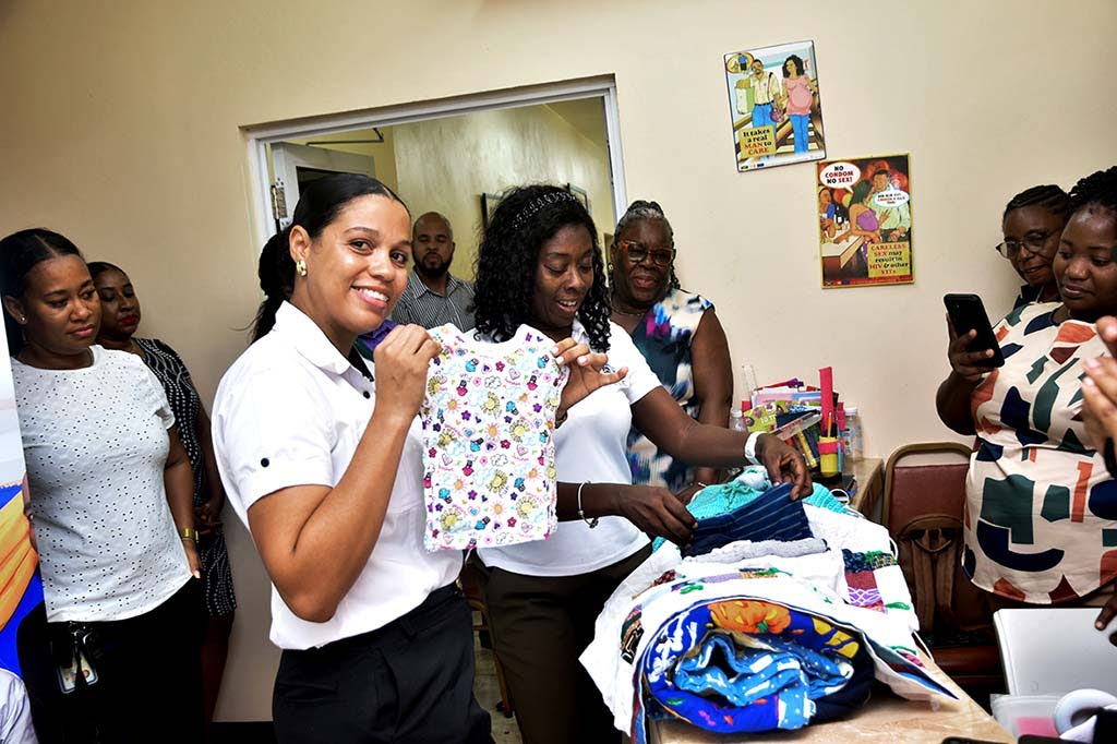Latoya Johnson-Jakala (left), centre manager, Junction and Santa Cruz outreach at the Women’s Centre of Jamaica Foundation accepts baby and personal care kits from Dawnette Pryce-Thompson (second left), project coordinator at the JN Foundation.