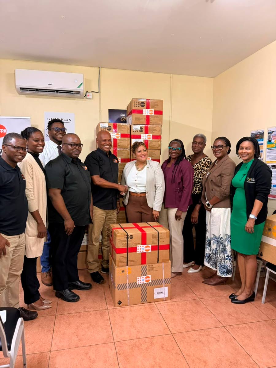 Harold Robinson (centre), director and representative, United Nations Population Fund (UNFPA) Sub-Regional Office for the Caribbean, formally hands over UNFPA’s donation of reproductive health and midwifery kits to Kristal Lee, Minister of State in the M