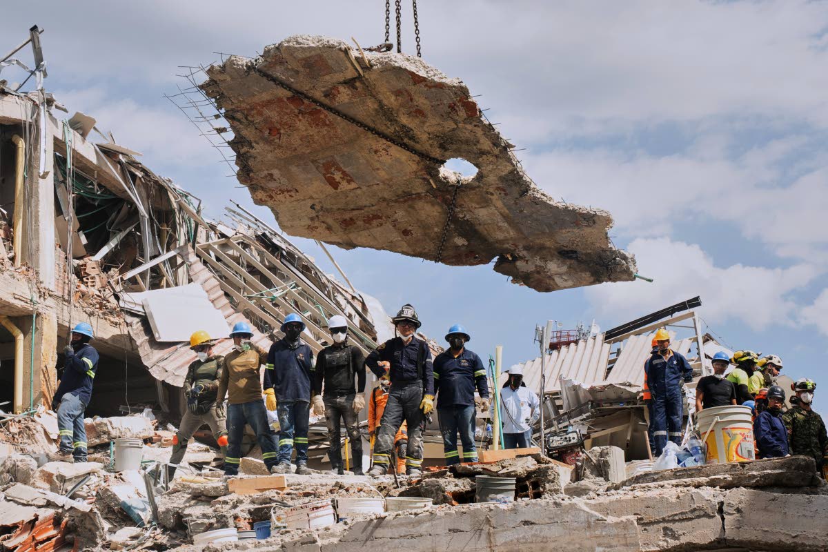 A crane lifts a concrete slab to clear the way for rescuers searching through the rubble three days after an earthquake hit Pereira, Colombia, last Thursday.