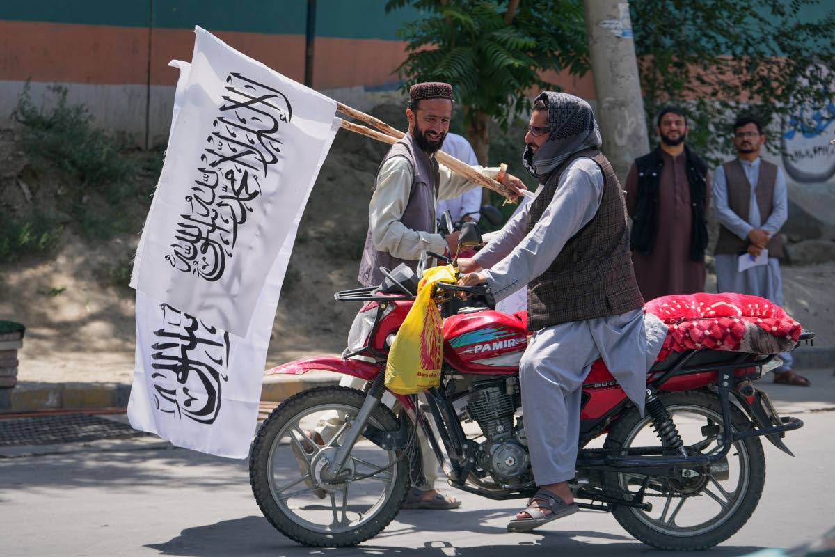 A man offers Taliban flags for sale ahead of celebrations marking the fifth anniversary of the US withdrawal from Afghanistan.