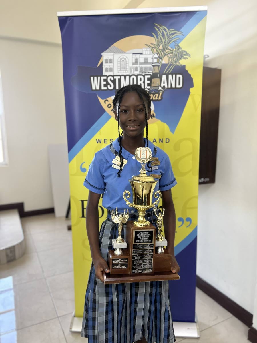 Khadijah Wright, who placed first in the Lay Magistrates’ Association of Jamaica essay competition, showcases the trophy awarded to her school following her victory.