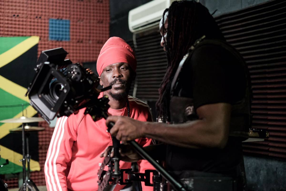Gayle (right) paused from a shoot with reggae star Anthony B to playback a filmed scene.