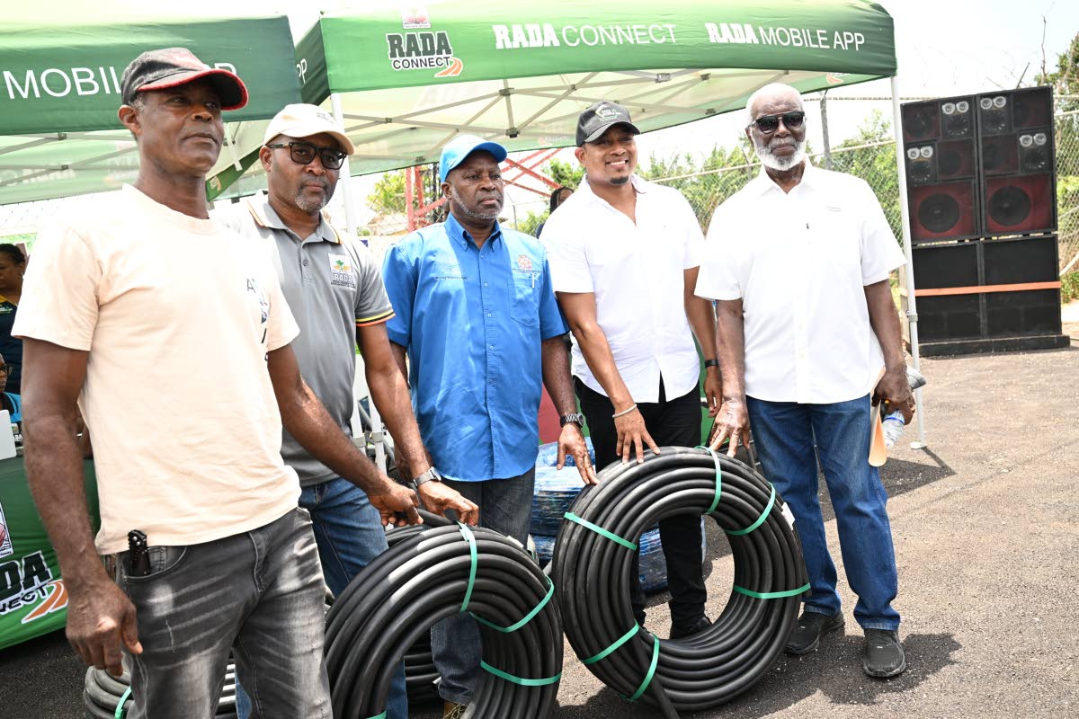 Minister of Agriculture, Floyd Green (second right), hands over irrigation supplies to a farmer, Jeffery Barnes (centre), from the Gillard area of Pedro Plains, St Elizabeth, during a ceremony on August 26. They are joined by (from left) CEO of the Rural A