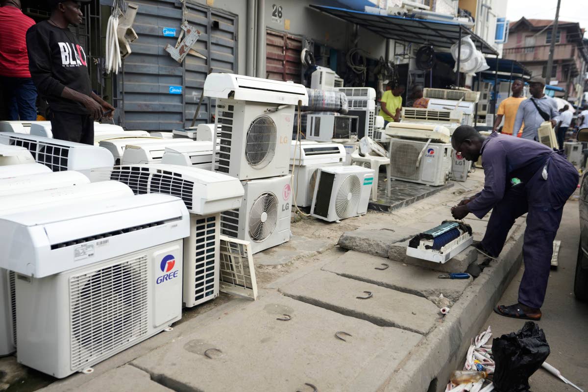 A man repairs air conditioners on the street in Lagos, Nigeria,.