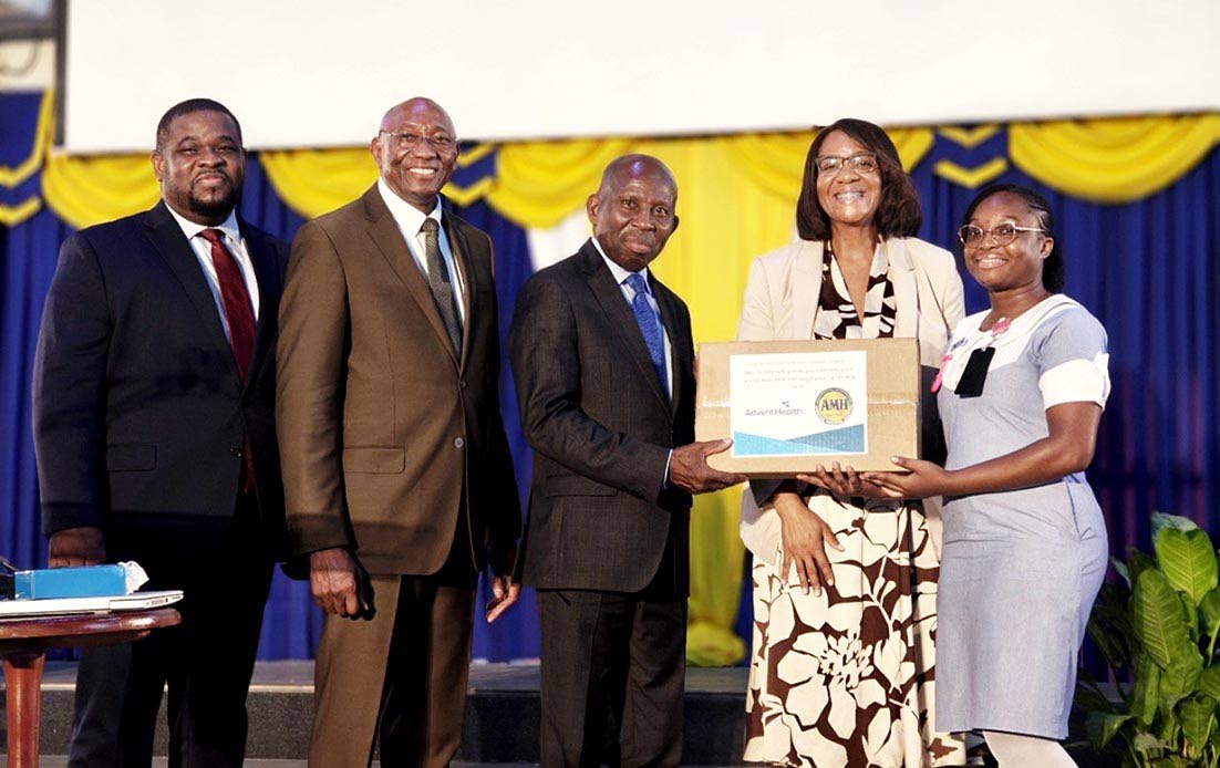 Final-year Northern Caribbean University (NCU) student Sonia Robinson accepts her HP laptop from Pastor Glen Samuels (third right), board chairman of NCU and president of the Jamaica Union Conference, and Dr Audrey Gregory (second right), senior executive 