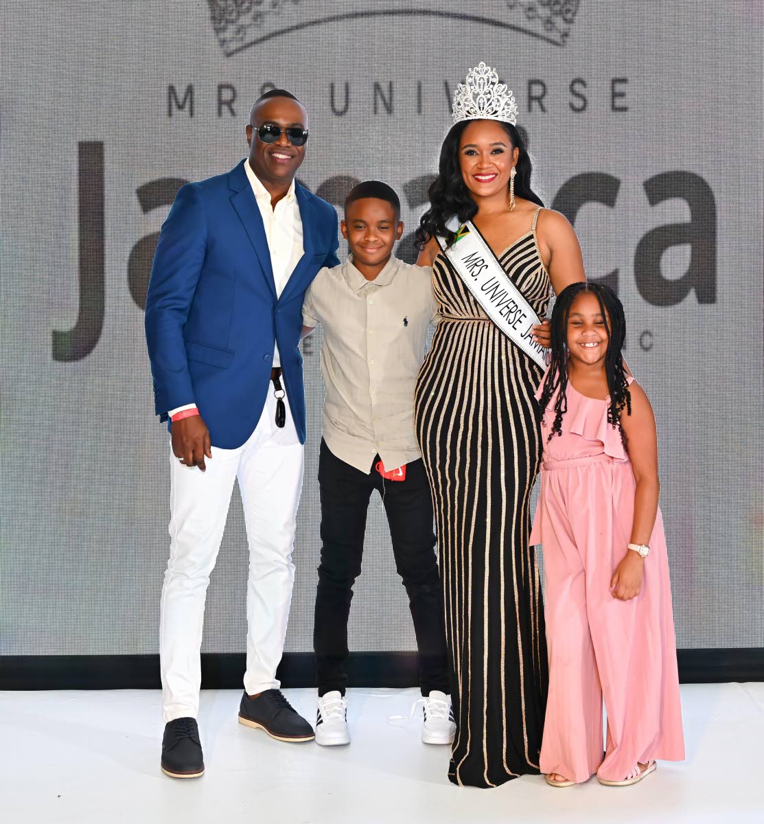 Fresh from her crowning, Mrs Jamaica Universe 2026 Dr Alicia Swaby Spencer celebrates the milestone alongside her husband, Dr Andrew Spencer (left), and their children, Andrew Spencer Jr (second left) and Amia Spencer (right). For the new queen, family rem