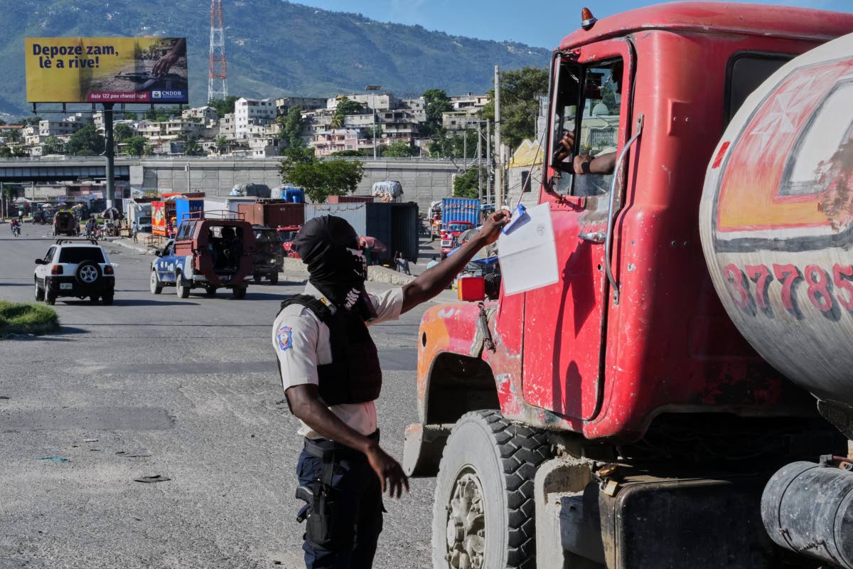 A police officer interacts with a truck driver as he patrols at an intersection in Port-au-Prince, Haiti.