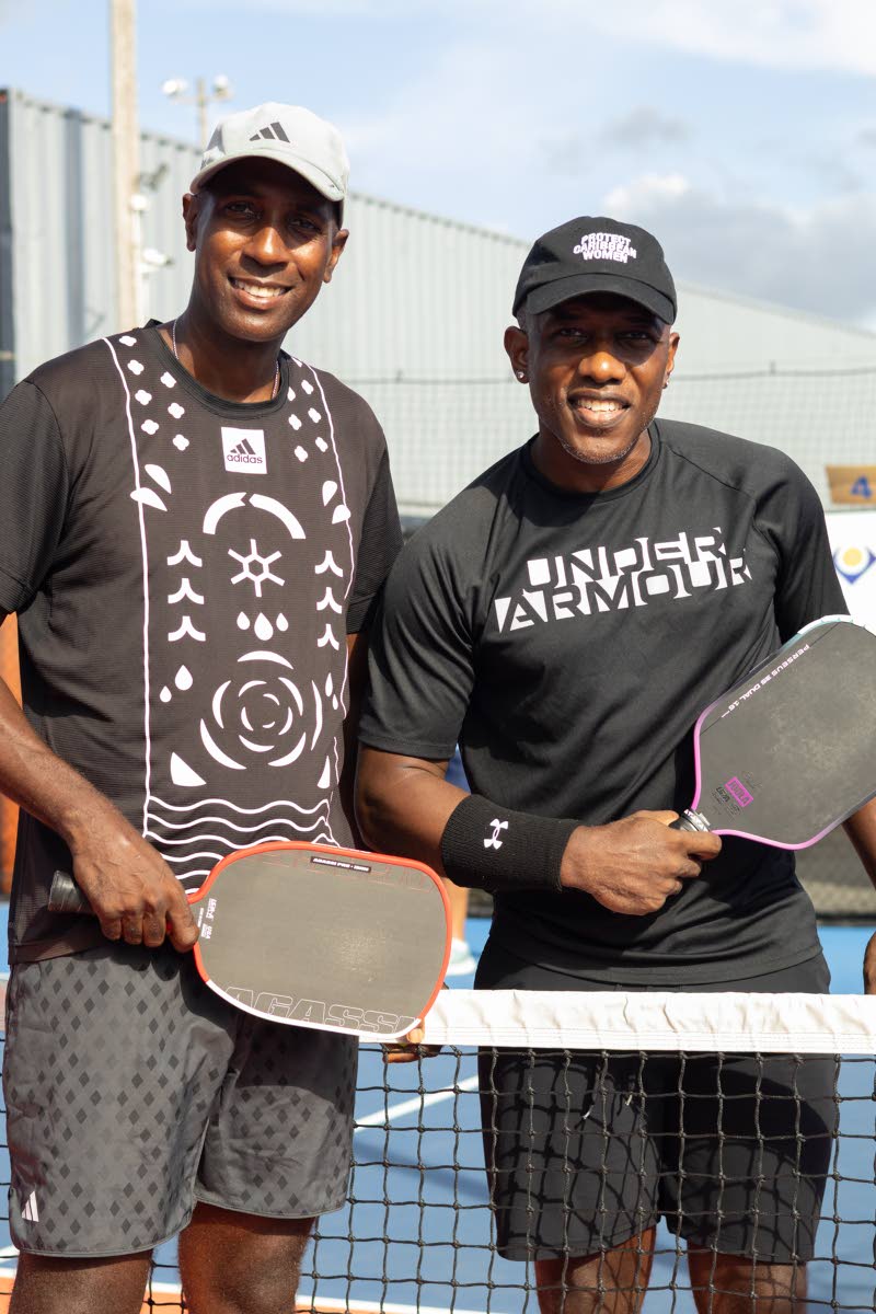 Dwayne Pagon (left) and Wayne Marshall from the Meet the Mitchells team pause for the camera at the net before getting down to business. 