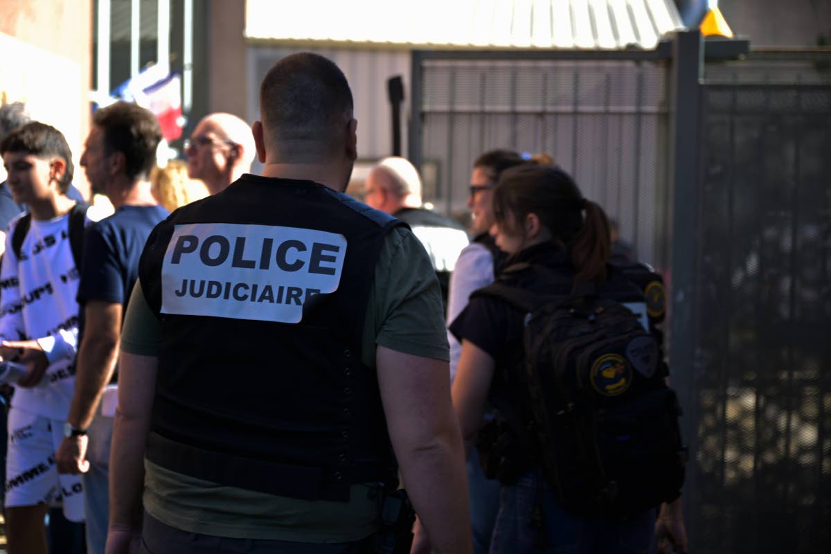 A police officer stands in front the Joseph Lakanal middle school after police have detained a 14-year-old pupil suspected in a rare school shooting, in Aubagne, France, Monday Oct. 12, 2026. (AP Photo/Philippe Magoni)