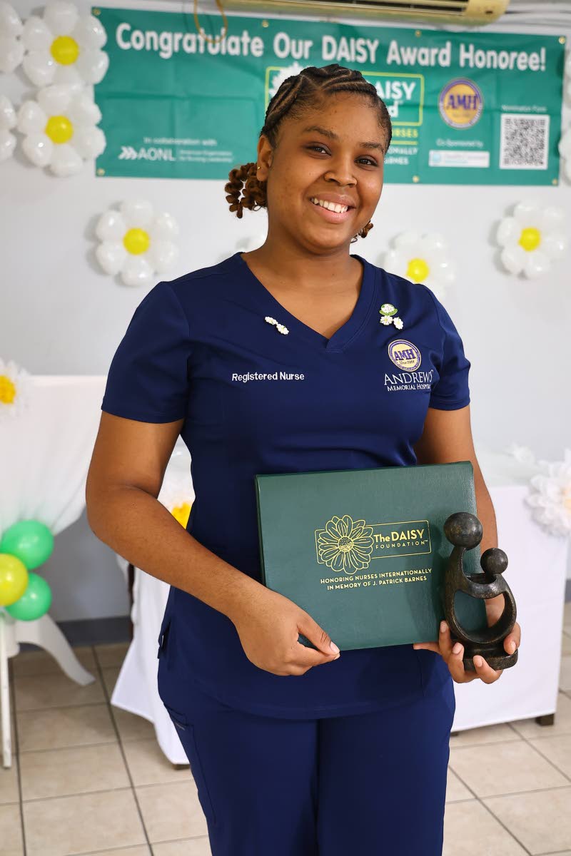 Registered nurse Merissa Geoghagen displays her DAISY Award certificate and the hand-carved Zimbabwean Healer’s Touch sculpture after being named the DAISY Award honouree at Andrews Memorial Hospital Limited.