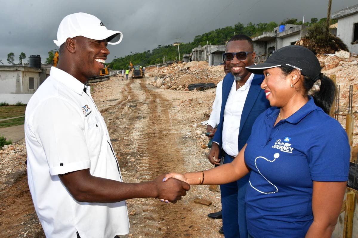 Luwanna Williams, JN Bank managing director, greets Delroy Reid, founder and director of DCR Construction and Development Limited, ahead of a tour of a model unit at Hosanna Estate in Beecher Town, St Ann on October 2. Recordero Setal (second right), sales