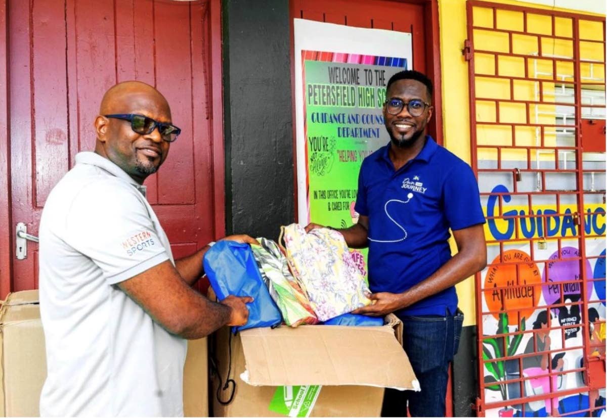 Roan Green (left), principal of Petersfield High School, collects a gift of school supplies from Omar Wright, lead, Environment and Community Development at the JN Foundation.