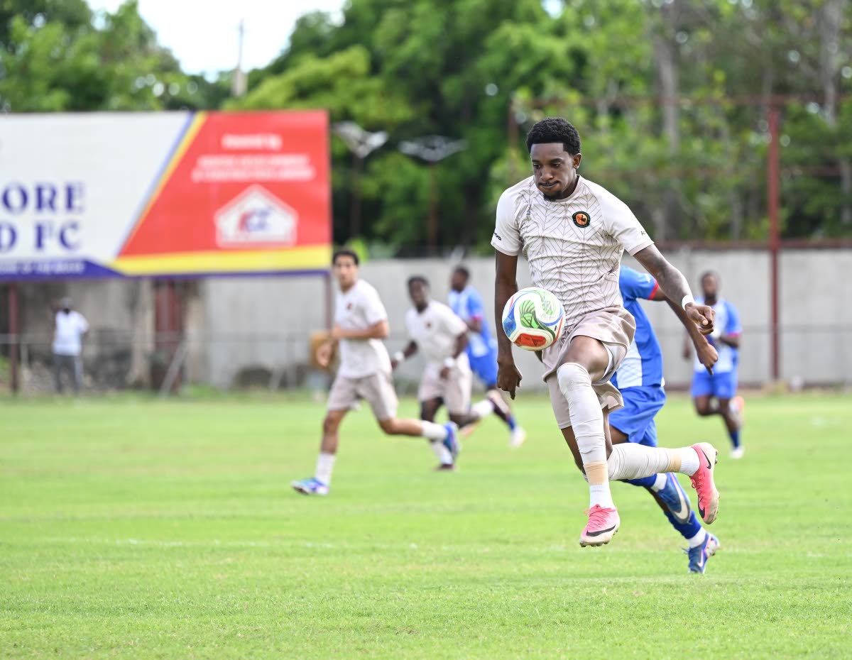 Chapelton Maroons’ Damoi Whitfield runs away from chasing Portmore United players during their Legend Jamaica Premier League fixture at Ferdi Neita Park yesterday. The game ended 0-0.