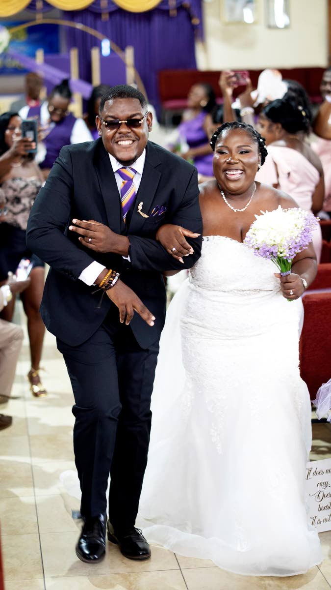 Beaming with joy, Akeeve and Throyann make their first walk as husband and wife.