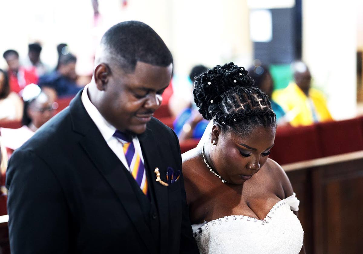 Akeeve and Throyann Barrett take a moment to pray during their wedding ceremony.