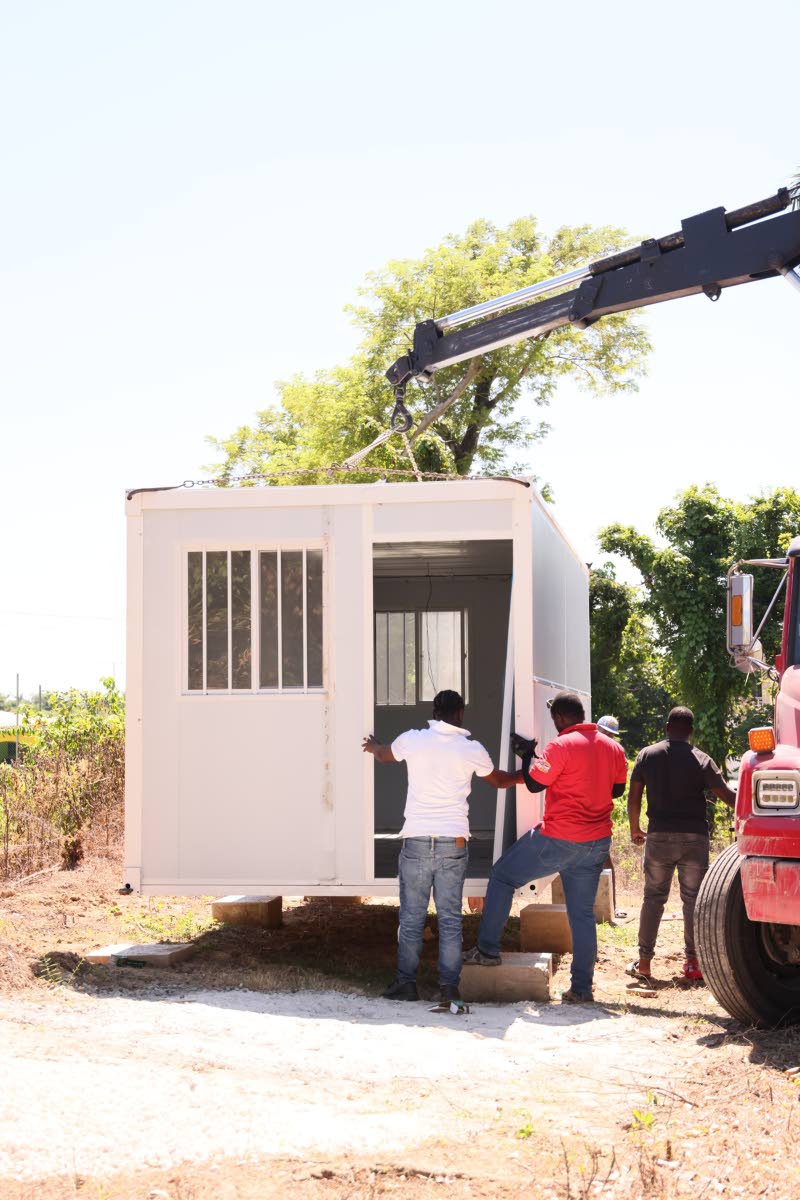 A crane lowers a prefabricated home into place for Robert James in Speculation district, St Elizabeth, on Thursday, October 22, as part of the FFK Cares Home Again initiative.