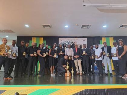 St Andrade Sinclair [seventh right, black coat], regional director of the Western Regional Health Authority [WRHA], in a group shot with several awardees assigned to the organisation’s maintenance division.