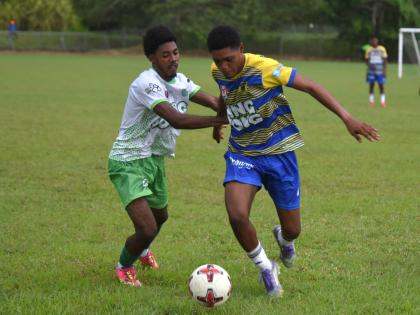 Rusea’s High School’s Maliek Headed (right) tries to shake the attention of Frome Technical High Schol’s Jevani Plummer during their Zone B match of an ISSA daCosta Cup at the Collin Miller Sports Complex. Lightning ended the contest at halfime with 