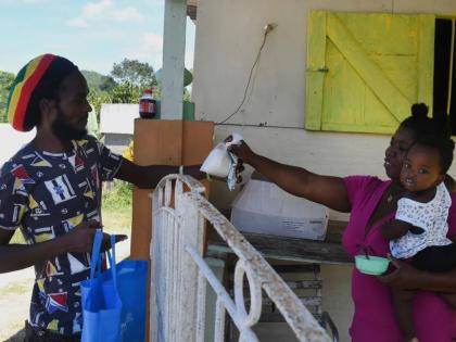 Gavin James buys a packet of flour from shopkeeper Ann Marie Cawley in St Elizabeth, Jamaica, May 17, 2021. 