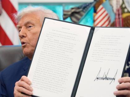 President Donald Trump holds a signed executive order regarding TikTok in the Oval Office at the White House, Thursday, September 25, 2025, in Washington. (AP Photo/Alex Brandon)