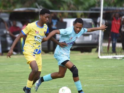 
St Elizabeth Technical High School’s Raheim Whyte (left) tries to stave off the challenge of Lacovia High’s Javier Clacken during their ISSA daCosta Cup Zone E football match at the STETHS Sports Complex yesterday.