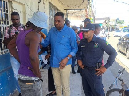 Mayor of Port Maria Fitzroy Wilson has a discussion with a fish vendor, while head of the St Mary police division, Superintendent Anthony Wallace looks on.