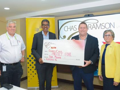 Phillip Ramson (second right), managing director of Chas E. Ramson Limited, presents a symbolic cheque valued at $4 million to Project STAR Director, Ian Neita (second left), marking the company’s two-year partnership with Project STAR to support communi