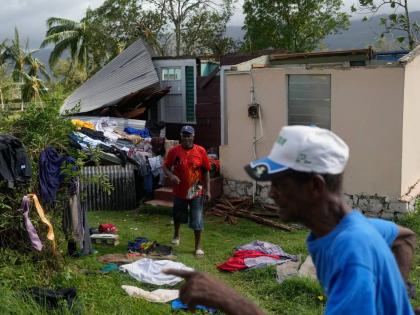 Residents dry belongings at a house damaged by Hurricane Melissa in Santa Cruz.