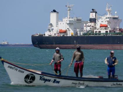Fishermen pass an oil tanker in the Gulf of Venezuela off the shore of Punta Cardon, Venezuela, January 14, 2026. (AP Photo)