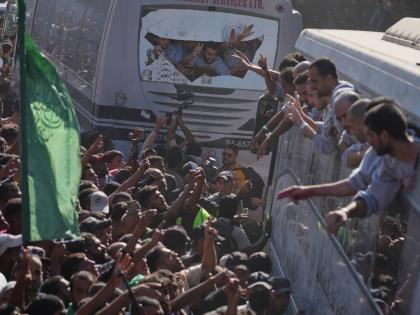 People gather to greet freed Palestinian prisoners arriving on buses in the Gaza Strip after their release from Israeli jails under a ceasefire agreement between Hamas and Israel, outside Nasser Hospital in Khan Younis, southern Gaza Strip on October 13, 2