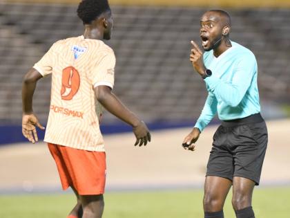 Robino Gordon (left) of Mona High School, is warned by referee Oshane Nation for rough play during the 2023 Manning Cup football final against Hydel High at the National Stadium.